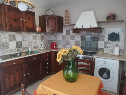 eine Küche mit einem Tisch und einer Blumenvase darauf in der Unterkunft Le case di Grazia in Ioppolo Giancaxio