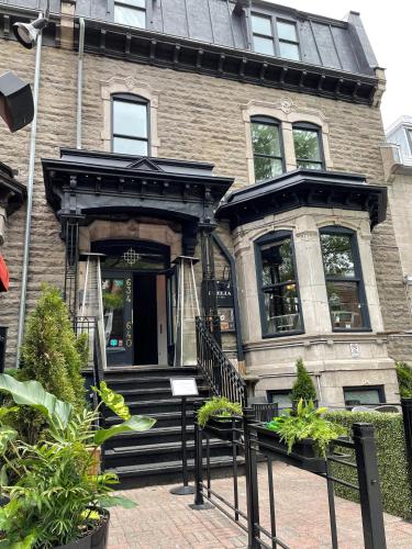 a house with a black bench in front of it at Hôtel Boutique Ophelia - Par Aneyro in Quebec City