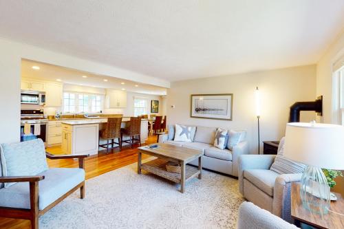 a living room with a couch and a table at Harborside Retreat in Falmouth