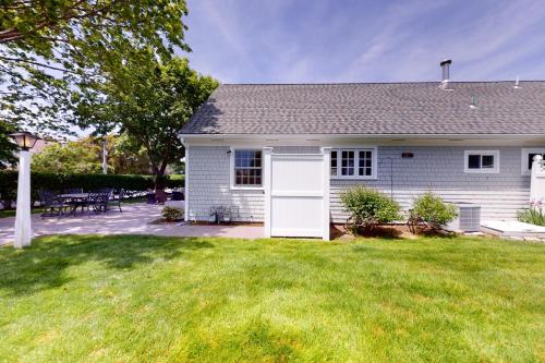 a white house with a lawn in front of it at Harborside Retreat in Falmouth