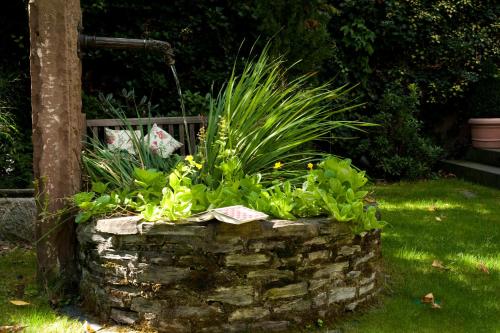 a stone wall with plants in a garden at Ringhotel Bömers Mosel Landhotel in Alf