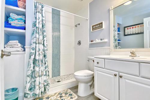 y baño con aseo, ducha y lavamanos. en Barefoot Beach Resort E102 en Clearwater Beach