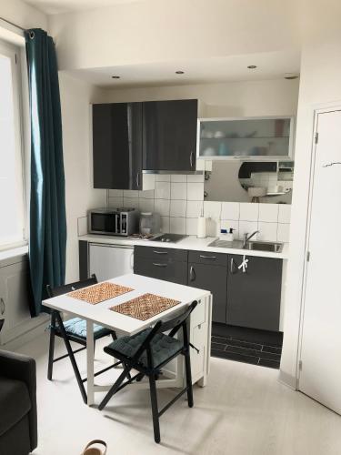 une cuisine avec une table et une petite cuisine avec un évier dans l'établissement Studio lumineux Saint-Ideuc à 1km de la plage, à Saint-Malo