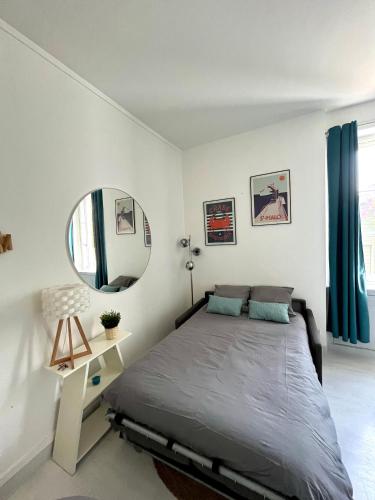 une chambre avec un grand lit et un miroir dans l'établissement Studio lumineux Saint-Ideuc à 1km de la plage, à Saint-Malo