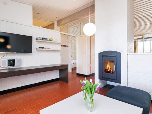 a living room with a fireplace and a couch at 6 person holiday home on a holiday park in Sæby in Sæby