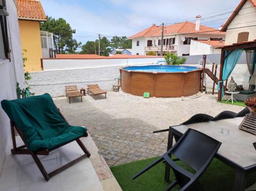 eine Terrasse mit Stühlen und einem Pool in der Unterkunft Comfort Beach house in Nazaré
