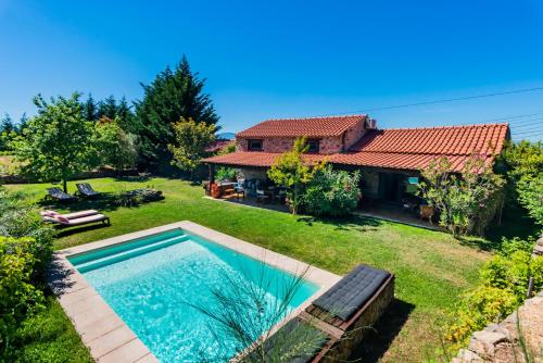 a backyard with a swimming pool and a house at Quinta da Pereira in Armamar