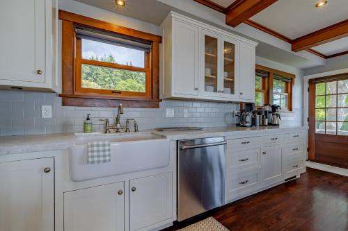 a kitchen with white cabinets and a sink and a window at Trinidad Pearl in Trinidad
