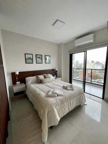 a bedroom with a large bed and a large window at Altos de Argentina in San Miguel de Tucumán