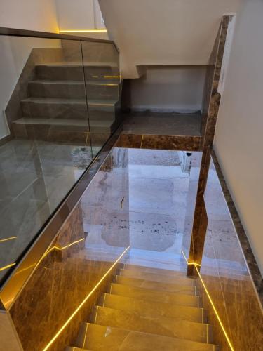 a stairwell with a glass railing and wooden stairs at Ebra Lux Apartmani in Dobra Voda