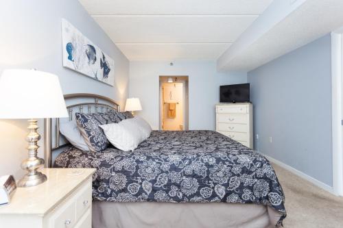 a bedroom with a bed and a dresser at Beachdrifter 406 in Jacksonville Beach