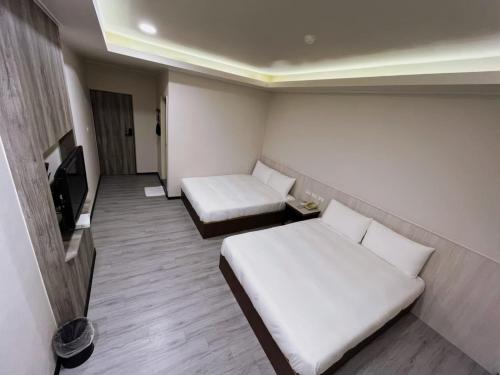 Habitación pequeña con 2 camas y TV. en New KM Hotel en Jincheng