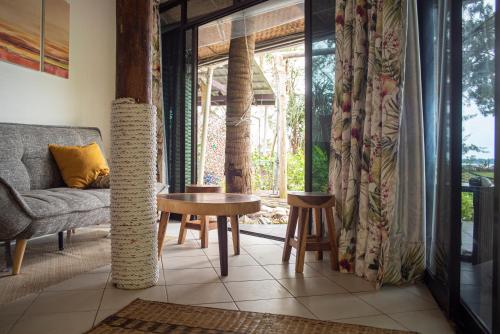 a living room with a couch and a table at GreenHouse EcoLodge in Mantanani Island 