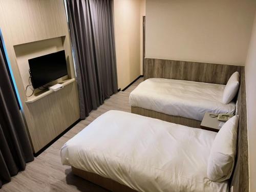 Habitación de hotel con 2 camas y TV de pantalla plana. en New KM Hotel en Jincheng