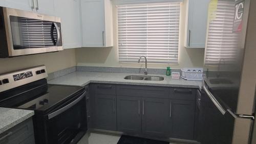 a kitchen with a sink and a stove at Scenic Ocean View Home in Lucea