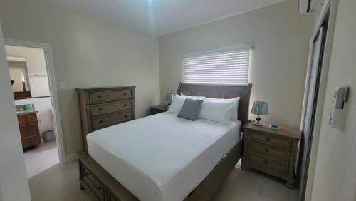 Scenic Ocean View Home في لوتسيا: غرفة نوم مع سرير أبيض كبير وخزانة