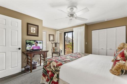 a bedroom with a bed and a flat screen tv at Beautiful 2 Bedroom Oceanview Condo at Maui Kamaole Located at South End of Kihei Adjacent to Wailea Traditional Hawaiian Style in Wailea