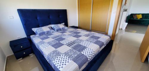 a blue bed with a blue and white quilt on it at Asilah Marina Golf in Asilah