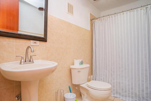 a bathroom with a sink and a toilet and a shower at Costa Ensenada Penthouse 505 across the street from Balneario beach in Rincon