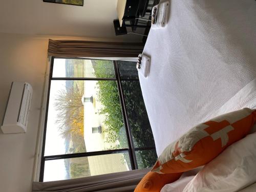 a bedroom with a window with a view of a building at Cedar Apartments - Merrijig in Merrijig