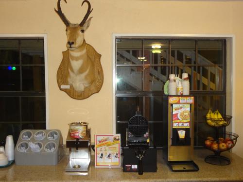 a fake deer head hanging on a wall next to a refrigerator at Antlers Inn Goliad in Goliad