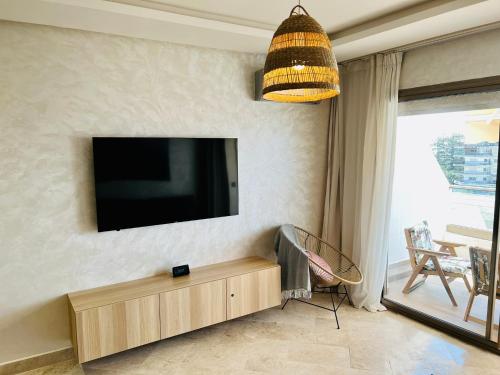 a living room with a flat screen tv on a wall at OceanParc - Vue sur Mer et Parc 24H Sécurité in Mohammedia
