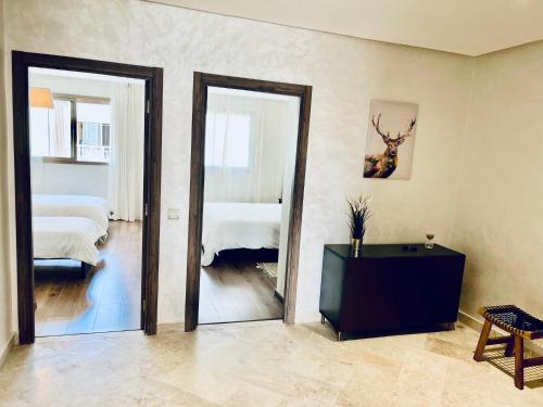 a room with a mirror and a bedroom with a bed at OceanParc - Vue sur Mer et Parc 24H Sécurité in Mohammedia
