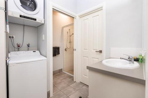 La salle de bains blanche est pourvue d'un lavabo et d'un lave-linge. dans l'établissement VILLA 17 CAPE VILLAS, à Dunsborough