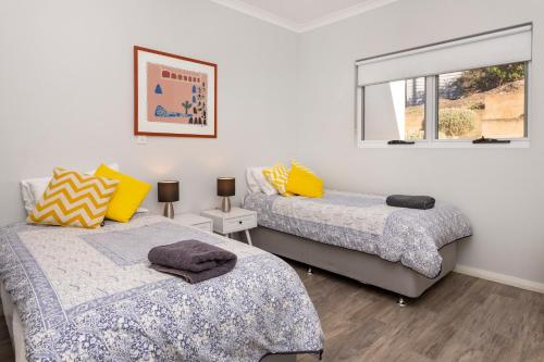 Un dormitorio con dos camas y una ventana. en VILLA 17 CAPE VILLAS, en Dunsborough