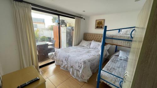 a bedroom with two bunk beds and a balcony at Calor De Hogar La Serena in La Serena