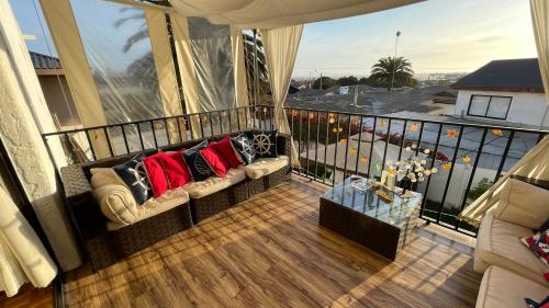 a balcony with a couch with red pillows on it at Calor De Hogar La Serena in La Serena