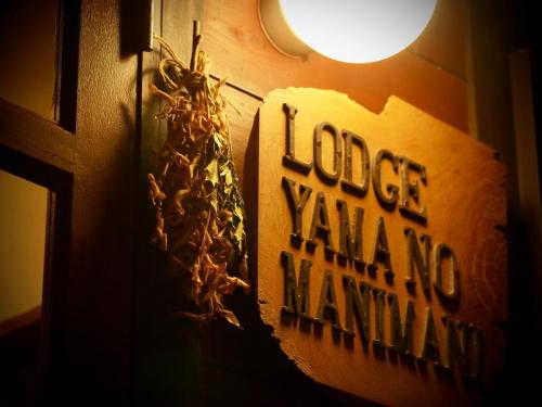 a sign on a door with a dog walking name at Okushiga Lodge Yama no Manimani in Yamanouchi