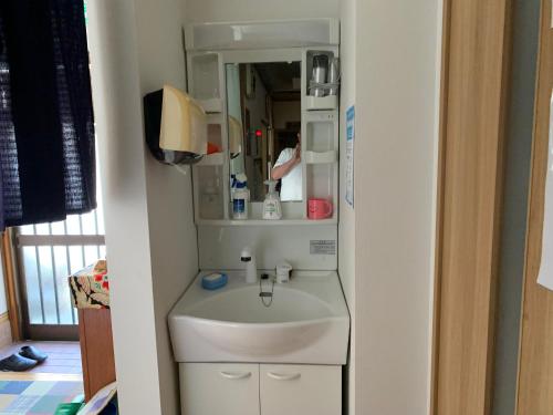 a small bathroom with a sink and a mirror at Buchoho No Yado Morioka in Morioka