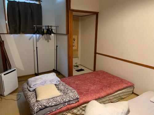 盛岡市にあるBuchoho No Yado Moriokaのツインベッド2台と鏡が備わる客室です。