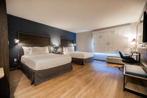 um quarto de hotel com duas camas e uma escrivaninha em Tru By Hilton Yarmouth, Ns em Yarmouth