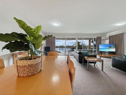 a living room with a table with a plant on it at Albacore Apartments in Merimbula