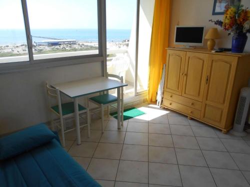 - un salon avec une table et une vue sur l'océan dans l'établissement Studio climatisé avec piscine et parking - Port Camargue - FR-1-250-239, au Grau-du-Roi