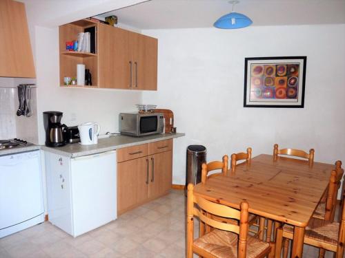 une cuisine avec une table en bois et un micro-ondes dans l'établissement 3 pièces avec parking, au pied des pistes à Saint-Jean-d'Aulps - FR-1-573-105, à Saint-Jean-dʼAulps