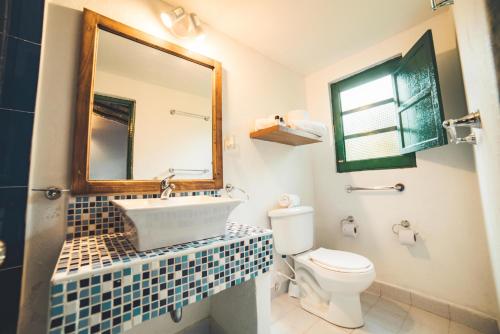 a bathroom with a sink and a toilet and a mirror at Estancia San Antonio in Guasca