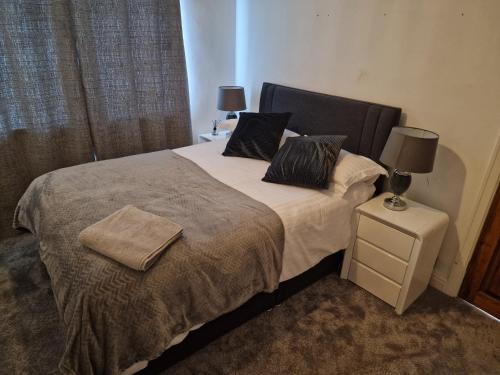 a bedroom with a bed with two pillows on it at L & J ESCAPES- 4 BEDROOMs SUITABLE FOR CONTRACTORS AND FAMILIES- LARGE PRIVATE PARKING-10 MINUTES TO M6 JUNCTION 9 in Coseley