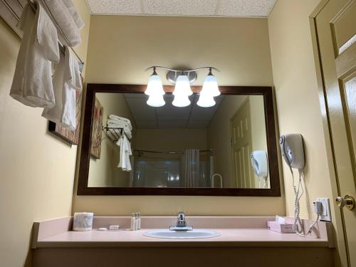 a bathroom with a sink and a large mirror at MountainView Hotel Merritt in Merritt