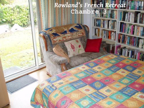 um quarto com uma cama, uma cadeira e uma estante de livros em Rowland's French Retreat em La Rochebeaucourt-et-Argentine