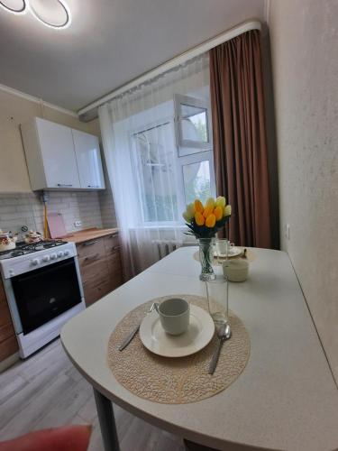 una cucina con tavolo e vaso di fiori di 2-х комнатная Квартира a Oral