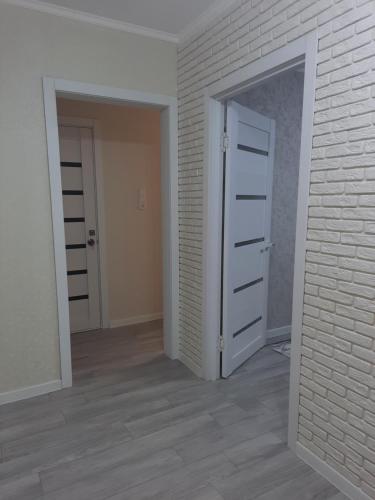 una habitación vacía con una puerta y una pared de ladrillo en 2-х комнатная Квартира, en Uralsk