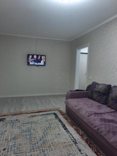 sala de estar con sofá y alfombra en 2-х комнатная Квартира, en Uralsk