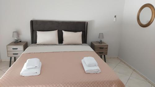 una camera da letto con un grande letto con due comodini di Gianni & Sophia airport house a Artemida