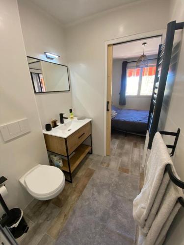 une salle de bain avec toilettes et lavabo et un lit dans l'établissement appartement vue mer avec place de parking privée, à Sainte-Maxime