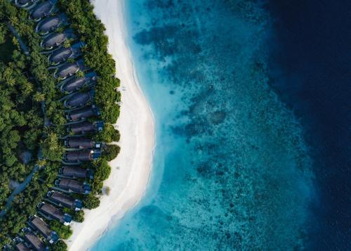 an aerial view of a beach with cabanas at Furaveri Maldives in Raa Atoll
