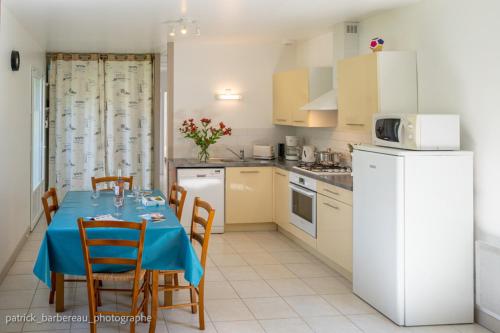 une cuisine avec une table et un chiffon bleu dans l'établissement Les Gîtes de Sophie 85 gite Capucine, à Saint-Gervais