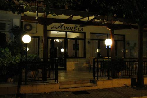 a restaurant with tables and chairs outside at night at Anixis Hotel in Loutra Ipatis